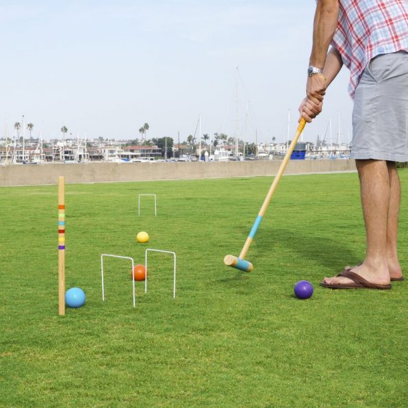 Man demonstrating how to play croquet
